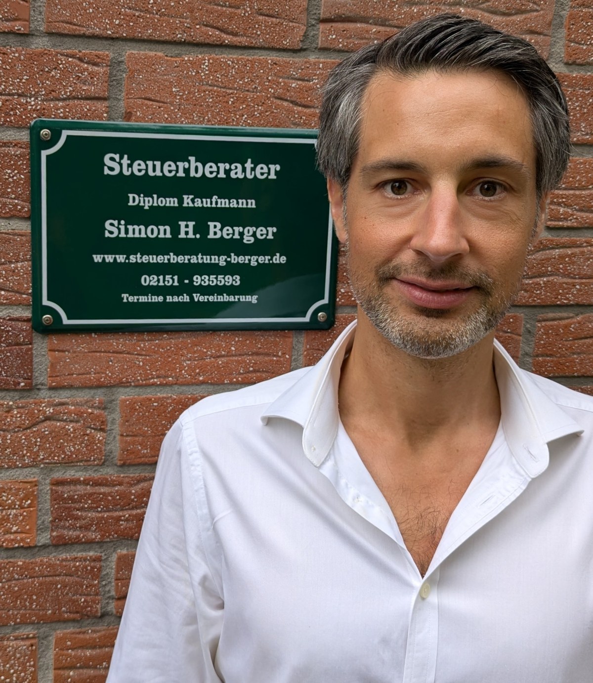 Simon Berger, Steuerberater und Diplom-Kaufmann, vor dem Kanzleischild in Krefeld-Fischeln